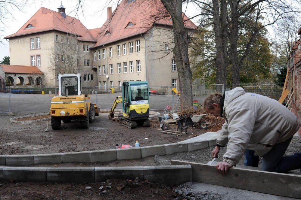 Noch sieht der Schulhof recht grau aus - künftig gibt es hier ein Grünes Klassenzimmer. Hier ist Roland Weilepp von der Firma Flaig-Bau zu sehen.