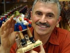 Der Seiffener Kunsthandwerker Jürgen Beyer zeigt am Donnerstag (04.11.2004) einen in seiner Werkstatt gefertigten Holzmichl, der exklusiv für «De Randfichten» produziert wird. (Foto: dpa)