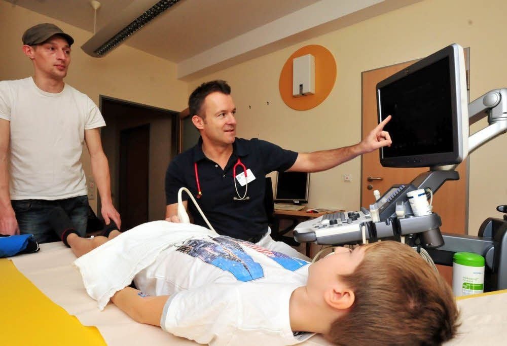 Ultraschall mit Chefarzt Daniel Windschall (M.): Patient Fabian und Vater Ralf Stengler in der Kinderklinik.