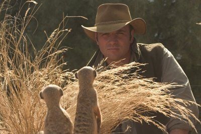 Der britische Tierfilmer James Honeyborne zusammen mit Erdmännchen bei den Dreharbeiten zu dem Kinofilm «Wächter der Wüste». Im Mittelpunkt steht das Erdmännchenjunge Kolo, dessen erste Schritte ins Leben die Zuschauer ebenso verfolgen können wie die Lektionen, die ihm der große Bruder erteilt, um dem harten Wüstenleben gewachsen zu sein. (FOTO: DPA)