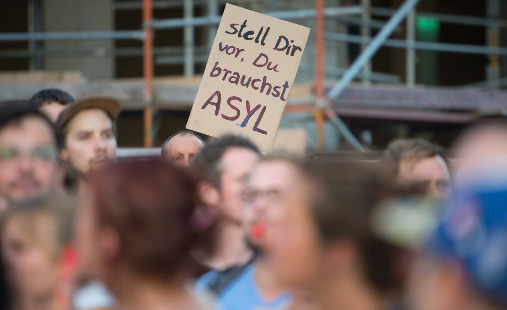 Gegner der islamkritischen Legida-Bewegung protestieren mit einem Transparent mit der Aufschrift "stell Dir vor, Du brauchst ASYL" in Leipzig.