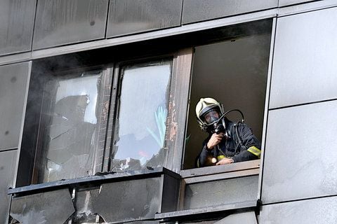 Ein Feuerwehrmann schaut nach einem Brand in einem Hochhauses in Erfurt aus einem von den Flammen zerstörten Fenster. (FOTO: DPA)