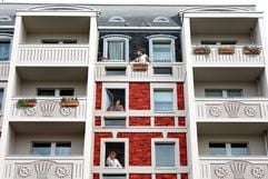 Die Illusion scheint perfekt - drei Mieter, die aus den Fenstern ihrer Wohnungen schauen, allerdings ist alles nur gemalt (Archivfoto vom 24.10.2006). Die Fassade gehört zu den sechs Blöcken rund um die Hellersdorfer Promenade, die die österreichische Firma Level One bis Frühjahr 2008 zum «Europaviertel Berlin» machen will. (Foto: dpa)