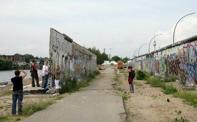 Touristen fotografieren und besichtigen Reste der Berliner Mauer am Spreeufer in der Nähe der Oberbaumbrücke. (FOTO: DPA)