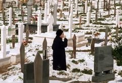 Eine alte Frau steht am Grab eines Angehörigen auf dem mit Schnee bedeckten Friedhof in Sarajevo, wo vor allem Opfer des Bürgerkrieges von 1991-1995 beerdigt sind (Archivfoto vom am 21.03.1998). (Foto: dpa)