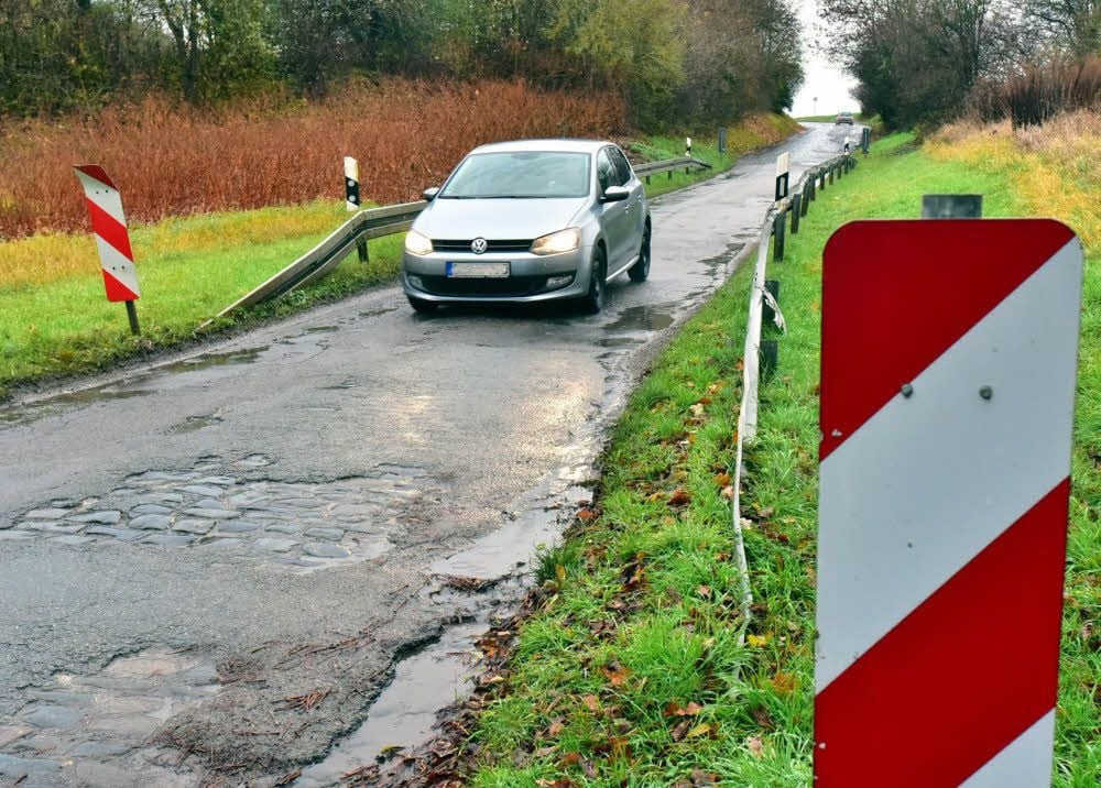Eine schmale Schlaglochpiste in die Straße von Hohenmölsen in Richtung Lützen , auf den Neunbau wird senhsnüchtig gewartet.