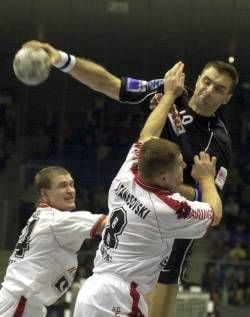 Der Jugoslawe Nenad Perunicic (SC Magdeburg) steigt am Samstag (17.11.2001) beim Champions-League-Spiel SC Magdeburg - Vardar Skopje (Mazedonien) in der Magdeburger Bördelandhalle hoch. Oleg Maljcev (l) und Kire Atanasovski können ihn nicht bremsen. Der deutsche Handballmeister gewann das Spiel in der Vorrundengruppe D mit 33:19 (17:6) Toren. dpa/lah