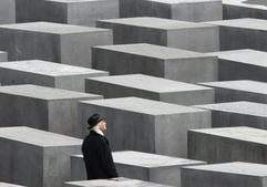 Ein Besucher des Holocaust-Mahnmals in Berlin läuft durch das Stelenfeld. (Foto: dpa)