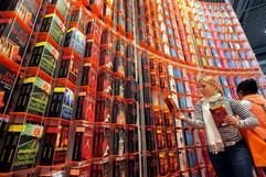 Besucher stehen am Donnerstag (16.03.2006), dem Eröffnungstag der Leipziger Buchmesse, an einer sehr hohen Bücherwand der Verlagsgruppe Droemer Knaur aus München. (Foto: dpa)