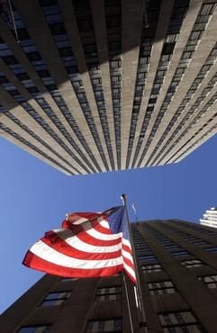Eine amerikanische Flagge weht im Oktober 2002 an einem Wolkenkratzer neben dem Rockefeller Center in Manhattan. Nahezu 20 Jahre nach der Schließung der Aussichtsplattform des Rockefeller Centers bekommt das Empire State Building durch die Wiedereröffnung der zweithöchsten Aussichtsplattform New Yorks wieder Konkurrenz. (Foto: dpa)