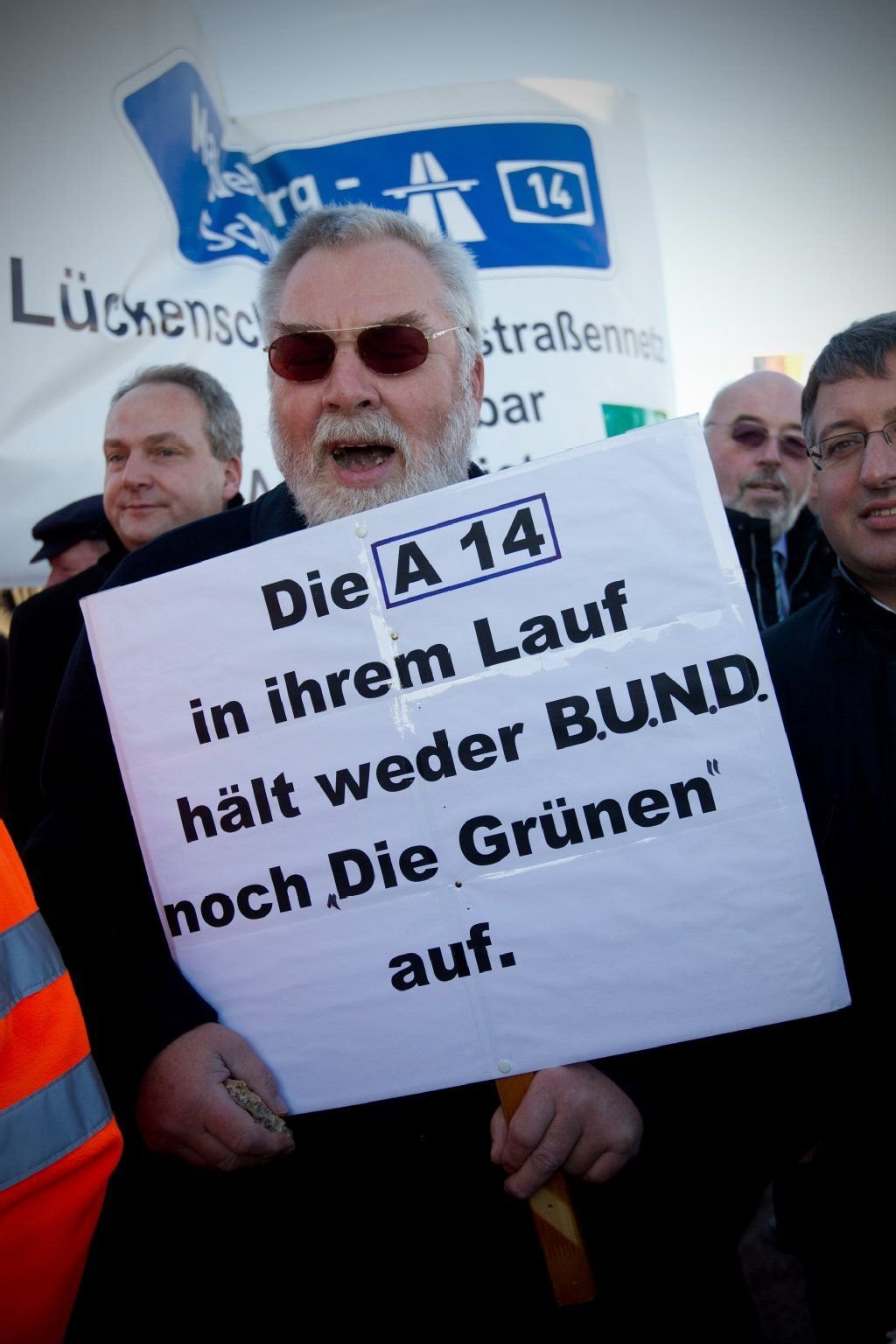 Ein Befürworter für den Bau der Nordverlängerung der Bundesautobahn 14 trägt im November 2011 am Rande des ersten symbolischen Spatenstiches in Colbitz (Sachsen-Anhalt) ein Schild.