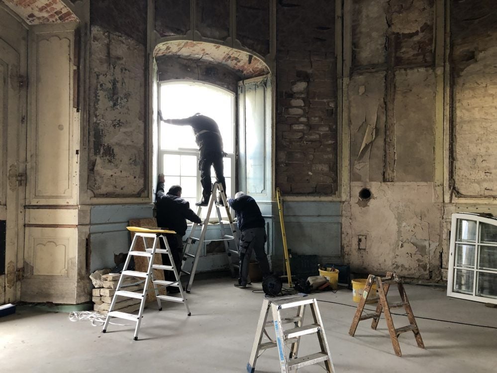 Mitarbeiter der Firma Crone bauen das Fenster im Pavillon ein.