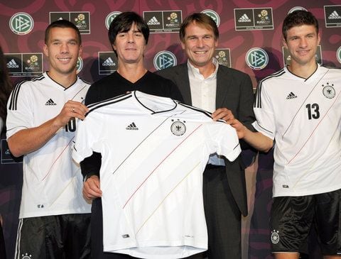 Der Trainer der deutschen Fußball-Nationalmannschaft, Joachim Löw (2.v.l.), Günter Weigl (2.v.r.), Geschäftsführer von adidas Market Central, und die Nationalspieler Lukas Podolski (l) und Thomas Müller (r) posieren bei der Vorstellung des neuen EM-Trikots in einem Autohaus in Hamburg mit einem Trikot. (FOTO: DPA)