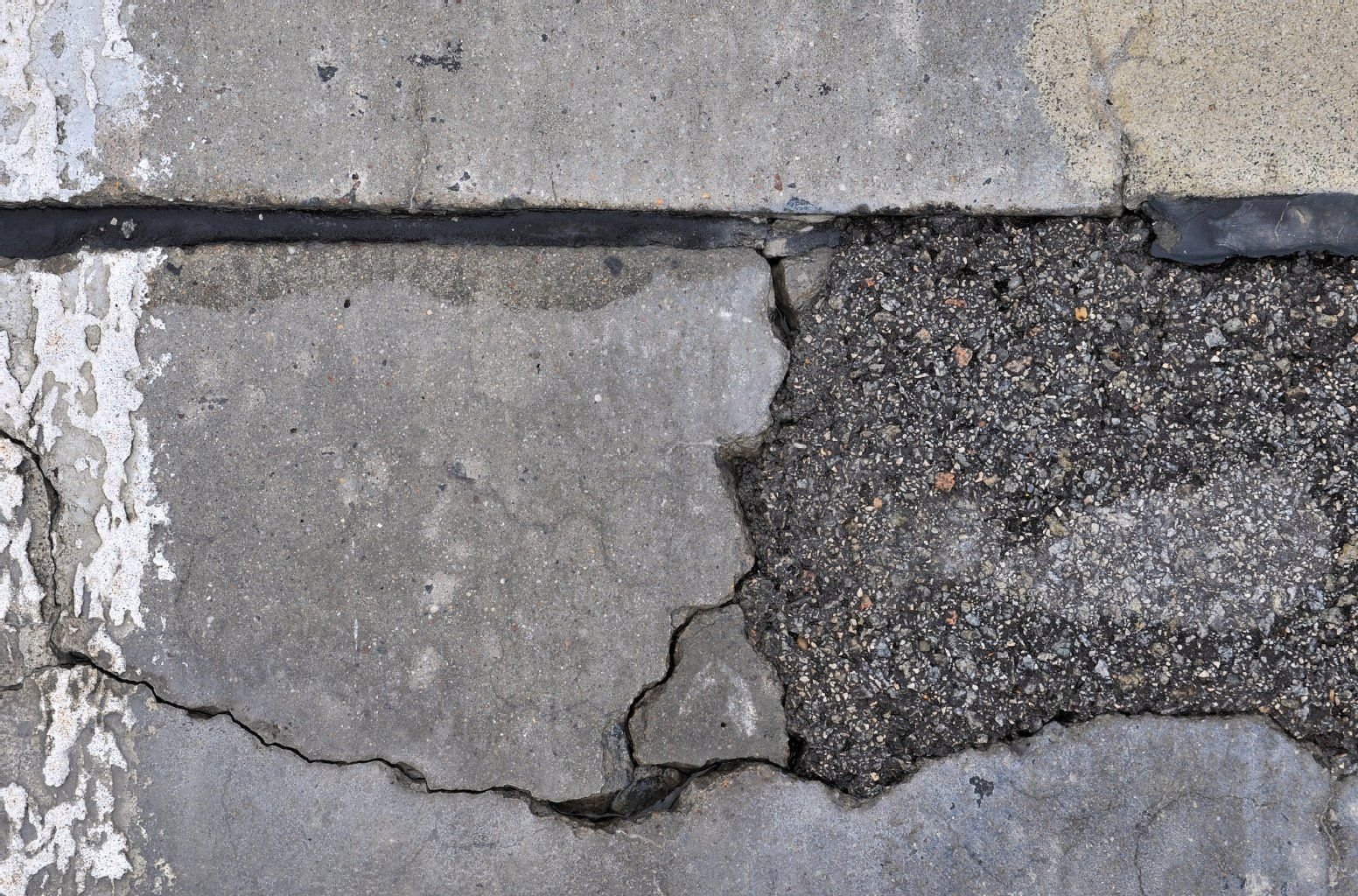 Risse und Flickstellen in der Betonfahrbahn zeugen von Schäden durch den sogenannten Betonkrebs.