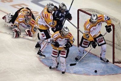 DEG Torwart Björn Linda (li.) schaut dem Puk nach einem Schuss eines Eisbärenspielers hinterher, während seine DEG-Mitspieler ein Tor verhindern. (FOTO: DPA)