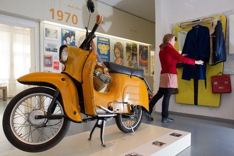 Katja Böhme vom Dokumentationszentrum Alltagskultur der DDR im brandenburgischen Eisenhüttenstadt (Oder-Spree) steht in der neuen Dauerausstellung neben einem Moped vom Typ Schwalbe. (FOTO: DPA)