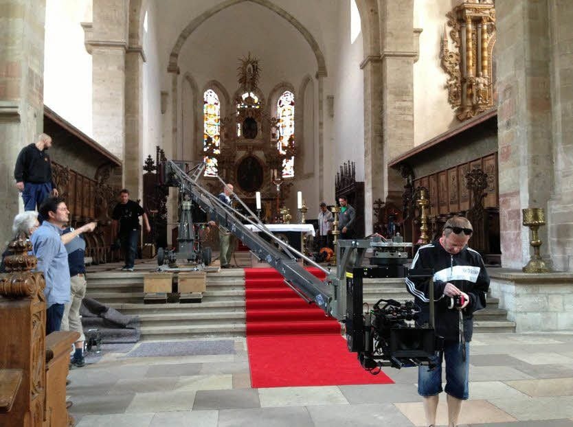 Die Filmcrew bereitet im Dom alles für die Dreharbeiten vor (l.). George Clooney selbst spielte in Merseburg in keiner Szene mit.