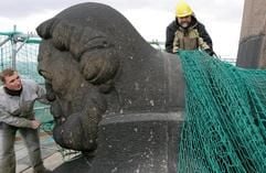 Auf dem Völkerschlachtdenkmal in Leipzig bereiten am Dienstag (04.04.2006) Oberflächenveredler Karsten Welz (l) und Oberbauleiter Ronald Börner in rund 78 Meter Höhe den Kopf eines Freiheitswächters für Reinigungsarbeiten vor. (Foto: dpa)