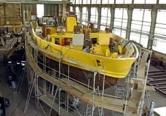 Ein Schiffbauer arbeitet auf der Werft in Genthin, die wie die Werft in Tangermünde zur Schiffbau- und Entwicklungsgesellschaft Tangermünde mbH & Co.KG gehört (Foto vom 21.07.2004). Im Hintergrund der Neubau eines Universalboot für das Wasserschifffahrtsamt Stralsund. Mit Fahrgastschiffen der Luxusklasse, Tankschiffen und Fähren hat sich das Unternehmen bisher einen Namen gemacht. Bis Ende 2005 gibt es nach Unternehmensangaben für die 110 Beschäftigten gut zu tun. Der Umsatz liegt derzeit bei 18 Millionen Euro im Jahr. Nach einer Pleite des Ostdeutschen Werftenverbundes 2002 übernahn die Peter Deilmann Reederei & Co. KG Neustadt in Holstein die Werften in Tangermünde und Genthin und gab seitdem jedes Jahr einen Luxusliner in Auftrag. (Foto: dpa)
