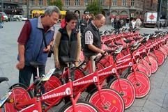 Interessierte schauen sich in Kopenhagen einige City Bikes an (Archivfoto vom 15.5.2002). In Kopenhagen können Einheimische und Touristen seit dieser Woche wieder 2000 Stadträder kostenlos und so lange sie wollen für Fahrten durch die Innenstadt benutzen. Zum Auftakt der zehnten Jubiläumssaison am Dienstag (19.05.2005) waren sich die Stadtverwaltung, der dänische Radlerverband und die Medien in ihren Lobpreisungen einig. «Die Kopenhagener lieben das Stadtrad, und die Touris sowieso», schrieb «Berlingske Tidende». (Foto: dpa)