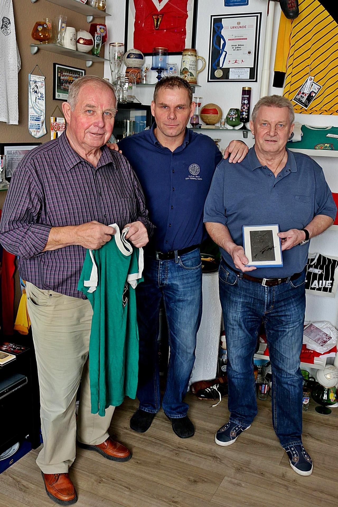 Uwe Sturm (M.) zeigt den Fußballlegenden Manfred Walter (l.) und Joachim Fritzsche sein Museum.