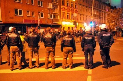 Polizeibeamte stehen bei einem Großeinsatz in Duisburg vor dem Clubhaus der Rockergruppe "Bandidos". Die gewalttätigen Auseinandersetzungen zwischen den Rockergruppen "Hells Angels" und "Bandidos" gehen weiter. (FOTO: DPA)
