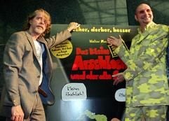 Der Entertainer und Musiker Helge Schneider (l) und der Moderator Ralph Morgenstern stehen am Filmplakat vor der Premiere des zweiten Teils des Comicfilms «Das kleine Arschloch» am Freitag (29.09.2006) in Halle. (Foto: dpa)