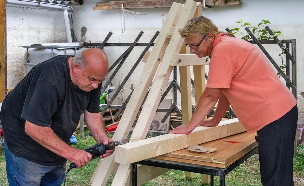 Rainer und Gabrielle Grundmann bauen eine Hollywoodschaukel. An den Wänden sind noch Spuren der Flut zu sehen.
