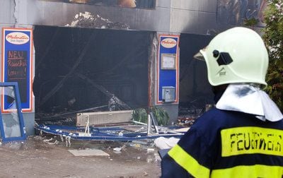 Ein Feuerwehrmann steht vor einer ausgebrannten Gaststätte in einem Einkaufscenter im brandenburgischen Eisenhüttenstadt (Oder-Spree). (FOTO: DPA)