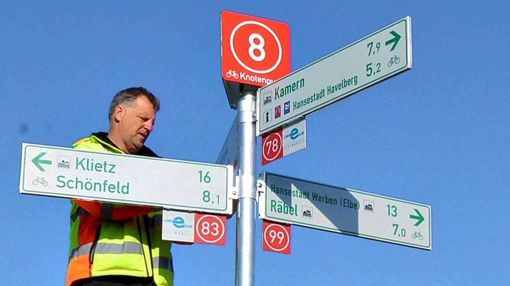 Jan Leisner montiert den Knotenpunkt-Wegweiser an der Sandauer Fährüberfahrt.