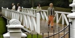 Besucher laufen im Gartenreich Dessau-Wörlitz über eine rekonstruierte weiße Holzbrücke im Luisium in Waldersee (Foto: dpa)