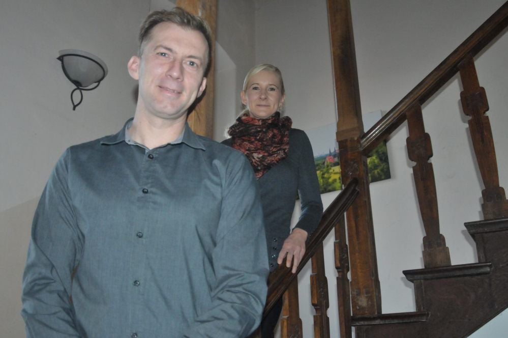 Dirk und Ines Große stehen auf der freitragenden Holztreppe ihres denkmalgeschützten Hauses, die in den 1920er Jahren nachträglich eingebaut worden war.