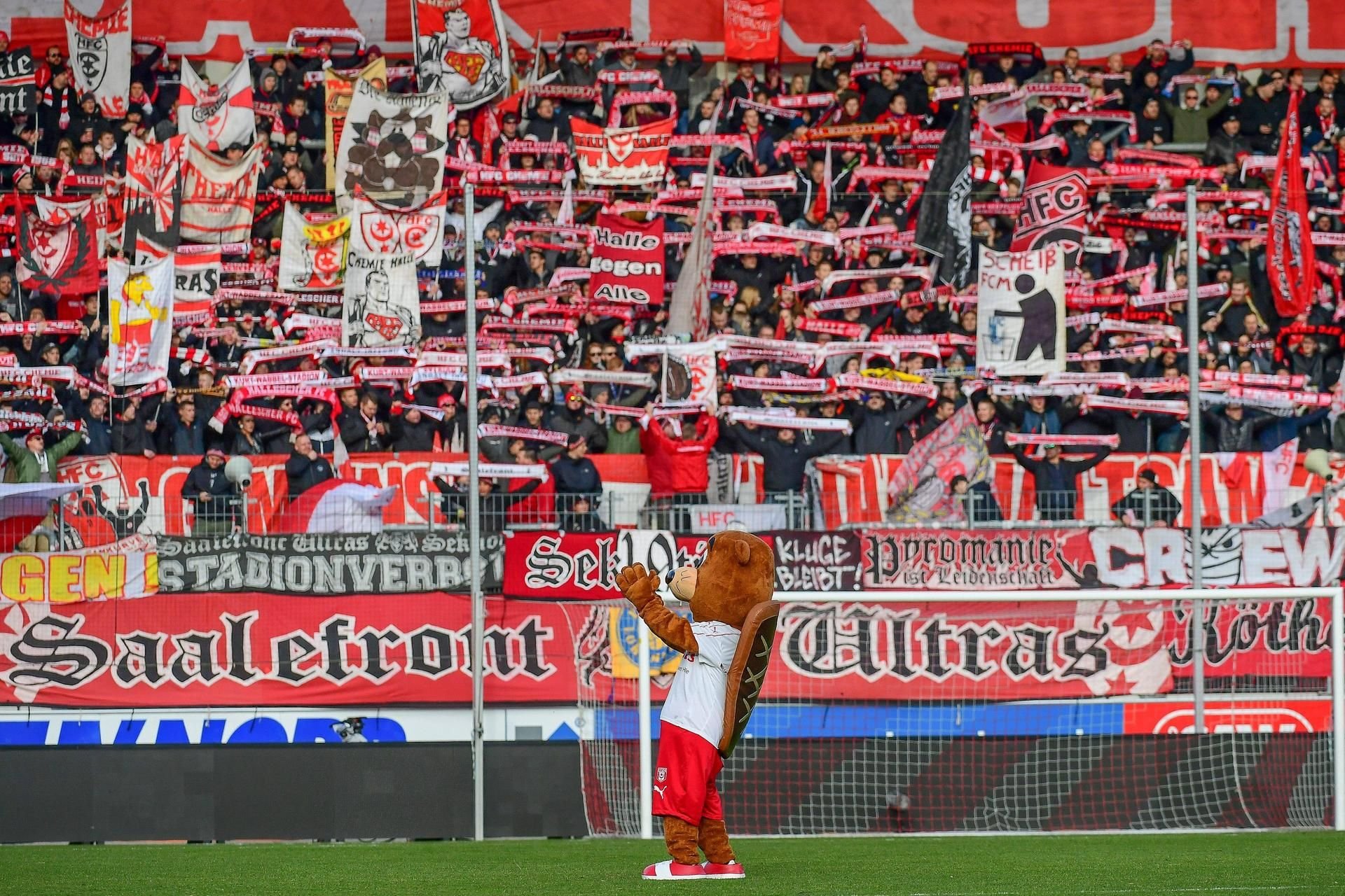 Hallotri, das Maskottchen des Halleschen FC, steht im Erdgas Sportpark in Halle und winkt in den Block der HFC-Fans.