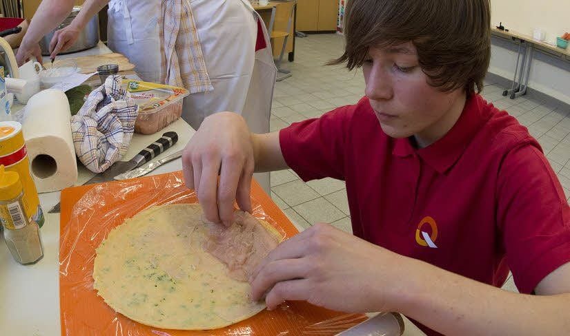 Ludwig Pohle wickelt Hähnchenbrustfilets ein.