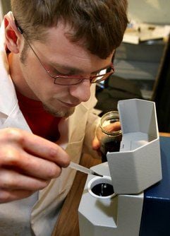 Stefan Huhnbein gibt in der Firma Panadur GmbH Halberstadt - der Betrieb trug bis Anfang 2008 den Firmennamen Harzlack Ltd. - eine Probe in ein neuartiges Nanopartikel-Messgerät. (Foto: dpa)