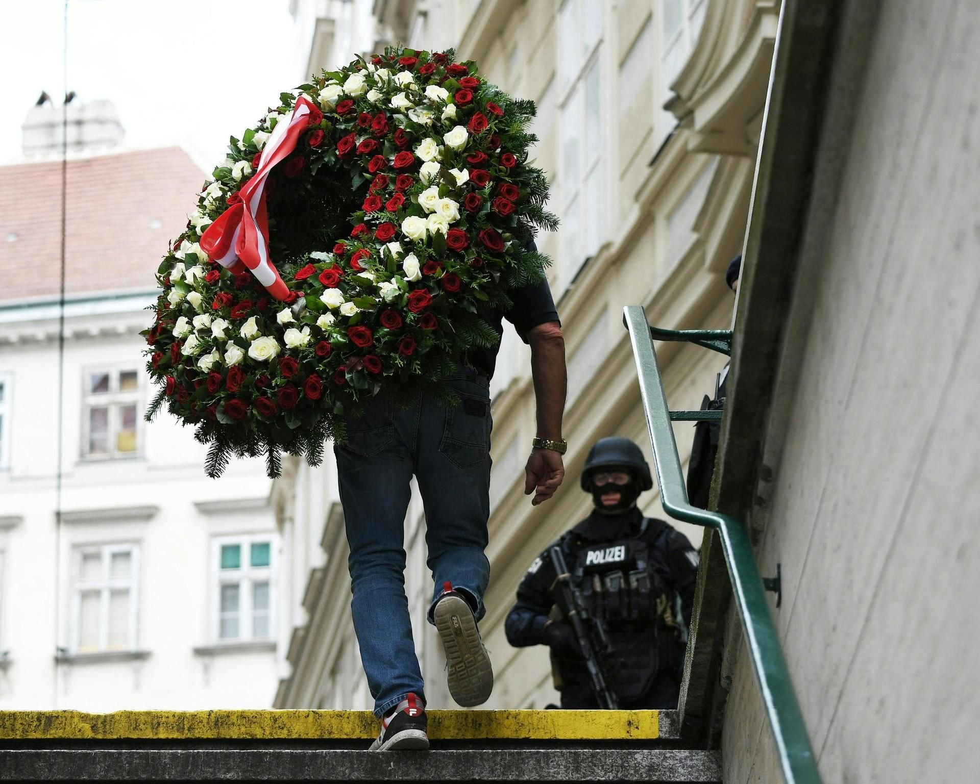 Ein Trauerkranz wird nach der Terrorattacke in Wien an den Tatort gebracht.
