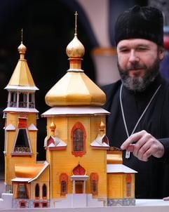 Boris Ustimenko, Erzpriester der russisch-orthodoxen Gemeinde in Magdeburg, steht am Baumodell für die russisch-orthodoxe Kirche in Magdeburg. (Foto: dpa)