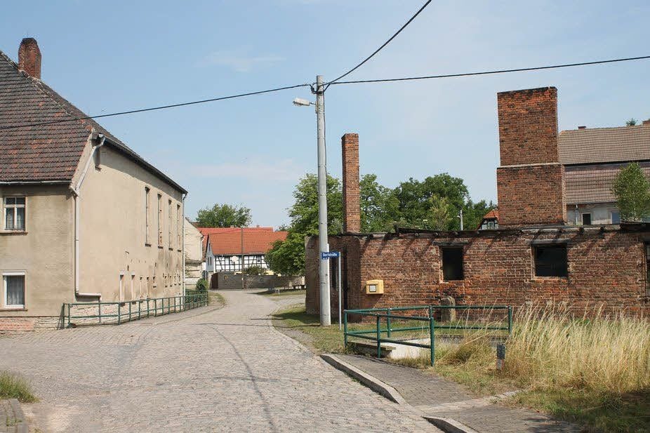 So blickt man heute zum ehemaligen Gasthof, in dem auch Häftlinge untergebracht waren, und zum Ziegelsteinbau, der als Küche und Lazarett des KZ-Außenlagers in Gleina diente.