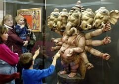 Besucher betrachten am Sonntag (27.11.2005) in neuen Ausstellungsräumen vom Museum für Völkerkunde im Grassi-Komplex in Leipzig einen aus Holz geschnitzten indischen Glücksgott mit 5 Köpfen und 10 Armen. (Foto: dpa)