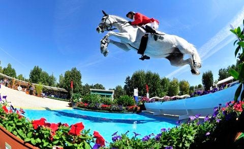 Der deutsche Reiter Marco Kutscher überspringt am Mittwoch (14.09.2011) bei der Europameisterschaft der Springreiter in Madrid auf seinem Pferd Cornet Obolensky das Wasserhindernis. (FOTO: DPA)