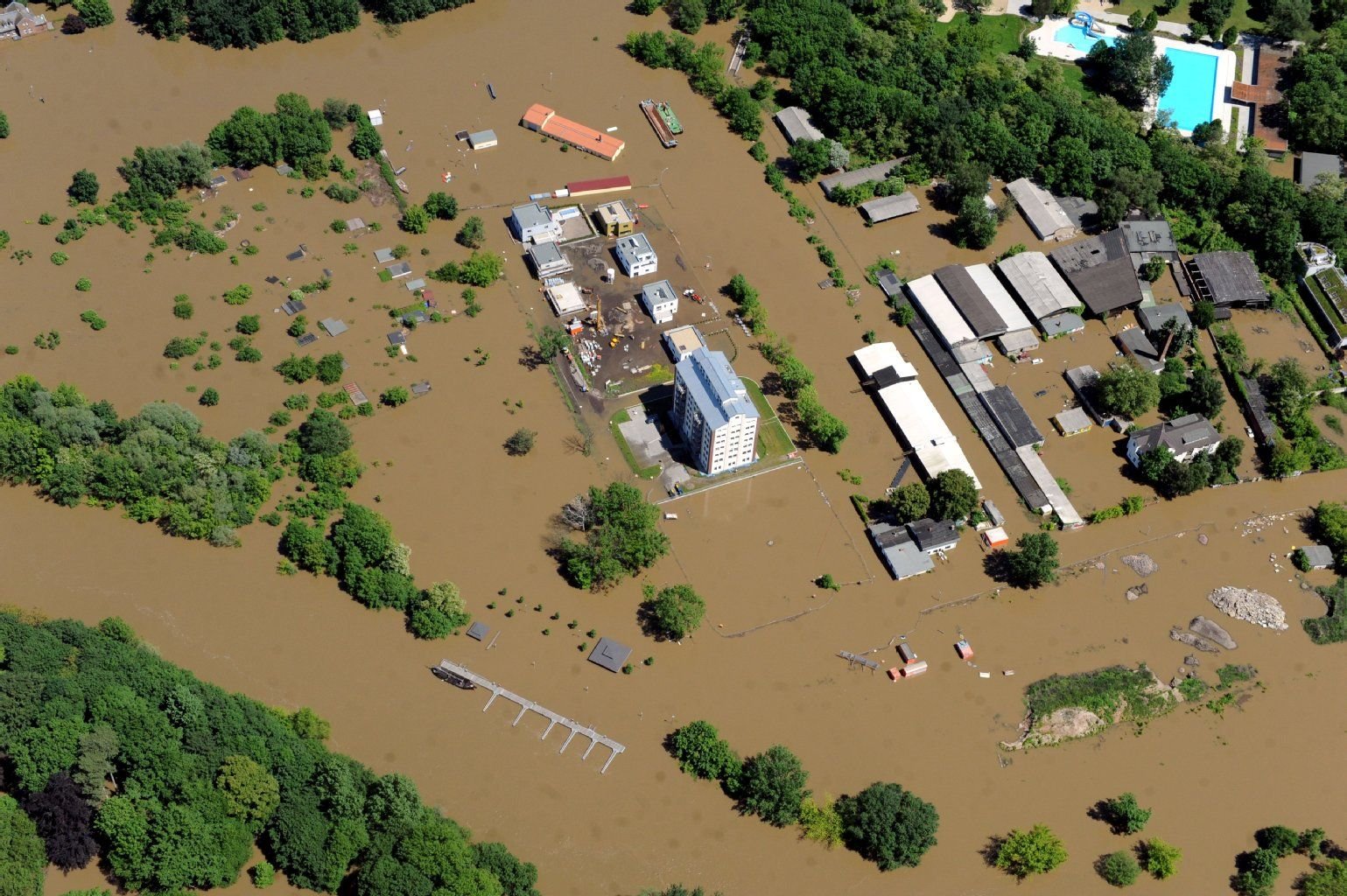 Hochwasser Luftaufnahmen: Die Hafenstraße mit Speicher und Saline Freibad in Halle.