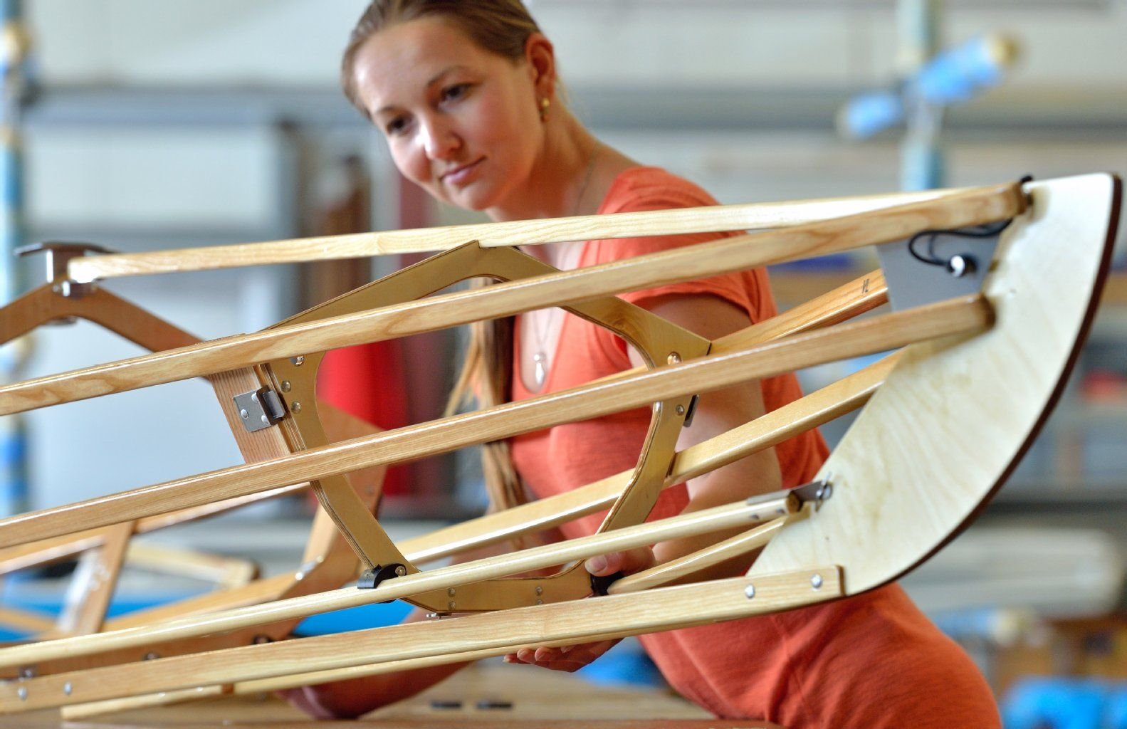 Katharina Seidel begutachtet den Holzrahmen eines Faltbootes. Sechs Modelle gehören derzeit zur Palette des Betriebes aus Sachsen-Anhalt.