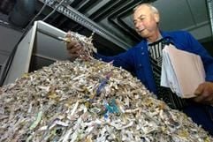 Der Angestellte Dieter Berndt zeigt am Donnerstag (22.1.2004) in der Aktenvernichtung des Kraftfahrt-Bundesamts in Flensburg zerschredderte Punkteakten. Im KBA werden jährlich rund 150 Tonnen nicht mehr benötigter Unterlagen vernichtet. Der Großteil der Akten, die im Reißwolf landen, stammen von Verkehrssündern. 2003 wurden gut 2,4 Millionen Sünderkonten annulliert. (Foto: dpa)