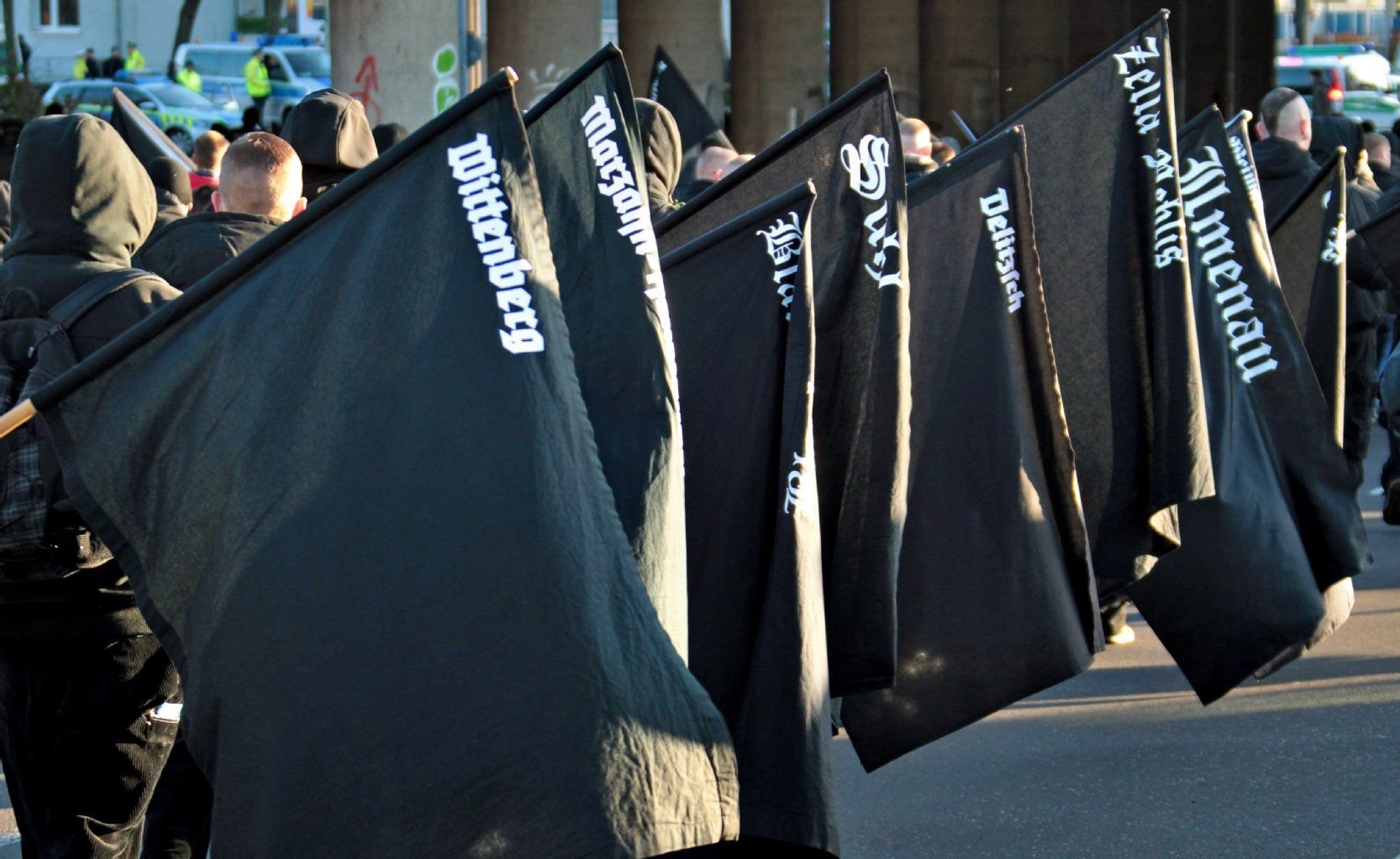 Teilnehmer gehen mit schwarzen Fahnen während einer Neonazi-Demonstration durch Magdeburg. Ein Jahr nach dem Start des neuen Aussteigerprogramms für Rechtsextreme hat der Verfassungsschutz in Sachsen-Anhalt elf Männer angesprochen und überprüft.