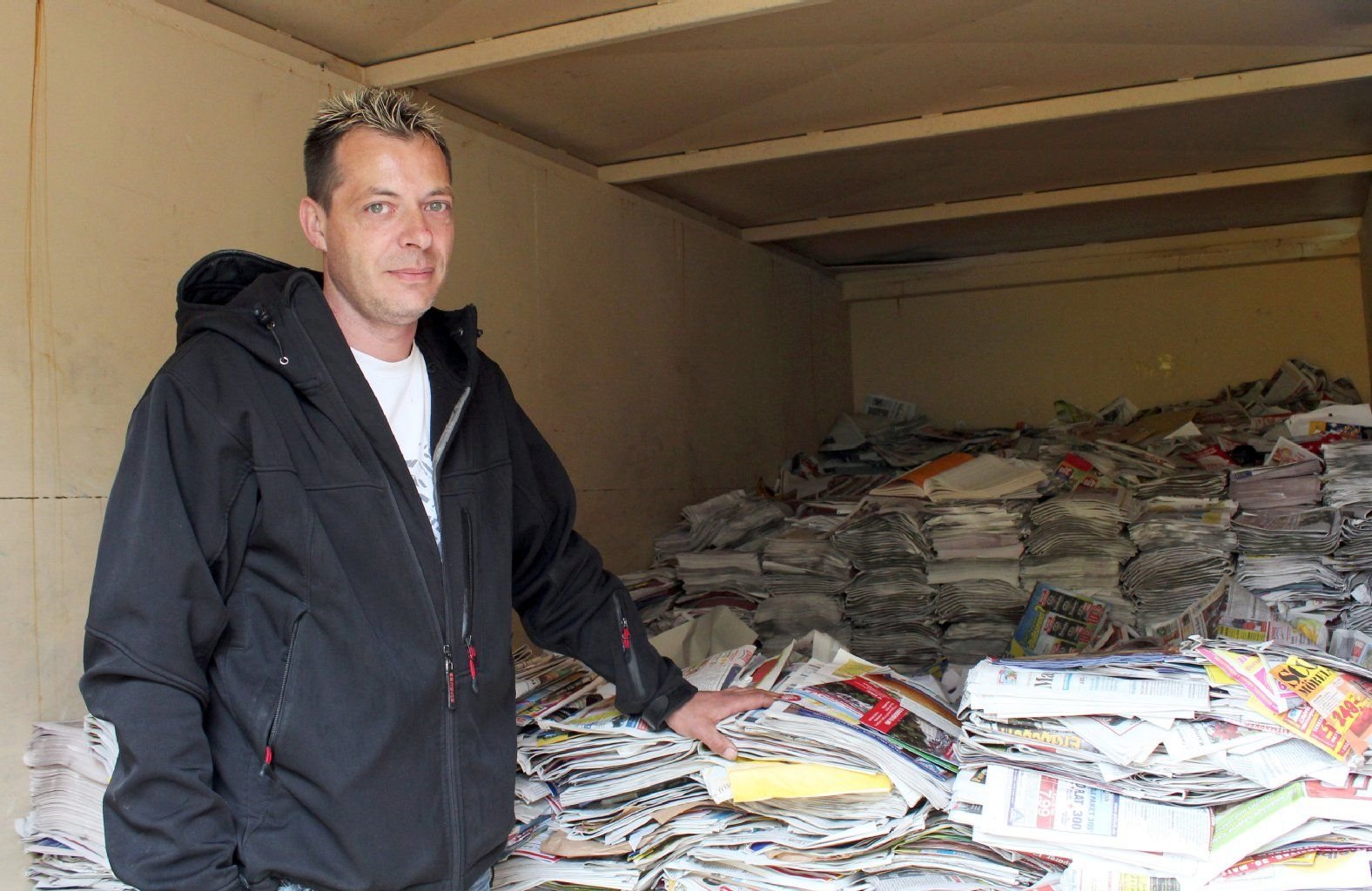 Michael Stakelies steht in Magdeburg (Sachsen-Anhalt) neben einem Container voller Altpapier in seiner Altpapier-Sammelstelle.