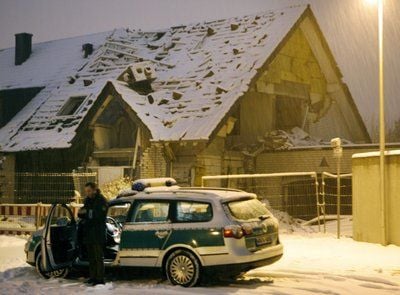 Ein Polizist steht in Jülich vor einem zerstörten und schneebedeckten Wohnhaus, das vermutlich durch eine Gasexplosion in die Luft flog. (FOTO: DPA)