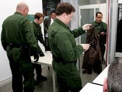 Polizeibeamte kontrollieren am Mittwoch (11.05.2005) im Karlsruher Landgericht die Kleidung von Besuchern. (Foto: dpa)
