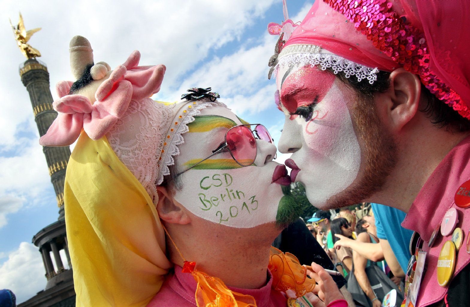 In bunten Kostümen küssen sich diese Männer in Berlin beim diesjährigen Umzug zum Christopher Street Day (CSD).
