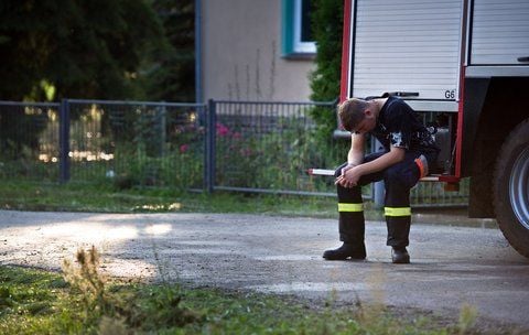Ein Feuerwehrmann sitzt am 09.08.2010 erschöpft am Heck eines Einsatzwagens während der Bekämpfung des Hochwasser der Neiße im brandenburgischen Pusack bei Döbern. (FOTO: DPA)