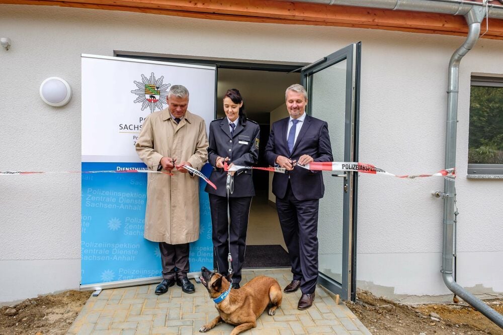 Innenminister Holger Stahlknecht (l.), die stellvertretende Leiterin der Hundeschule Katja Hillert und Andreas Grobe vom Bau-und Liegenschaftsmanagement Sachsen-Anhalt durchtrennen die „Polizeiabsperrung“.